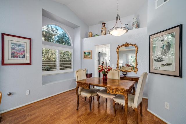 dining room with wood-type flooring and lofted ceiling