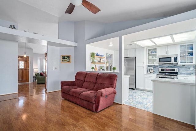 living room featuring light hardwood / wood-style floors, high vaulted ceiling, and ceiling fan