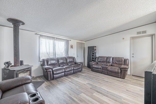 15035 E E Ave Unit G, Lancaster, CA 93535 - living area with a wood stove, light wood-type flooring, and a textured ceiling