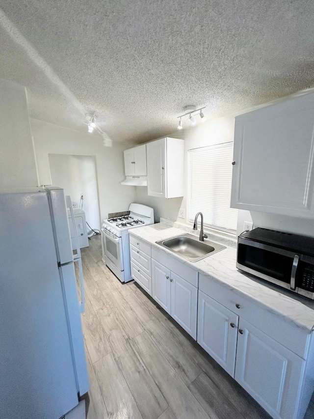 kitchen with white cabinetry, sink, light hardwood / wood-style floors, and white appliances