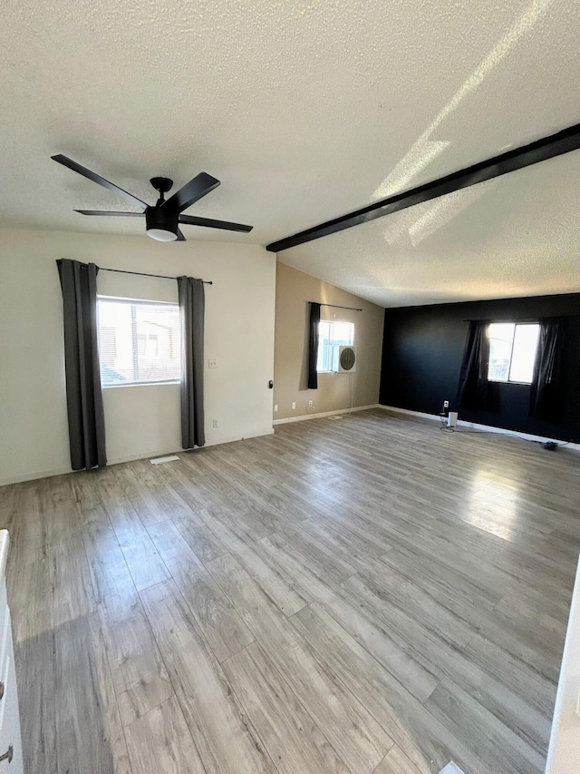 spare room featuring ceiling fan, light hardwood / wood-style flooring, a textured ceiling, and vaulted ceiling