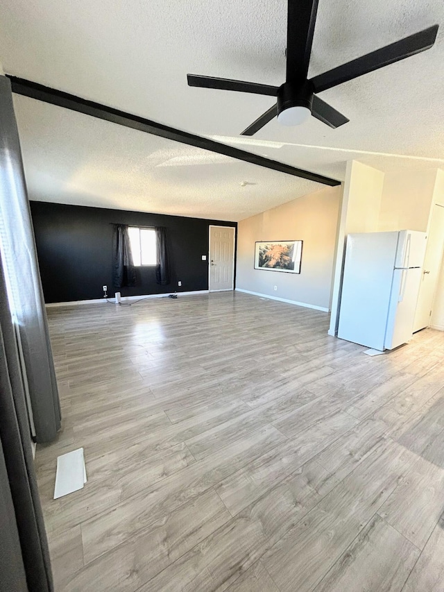 unfurnished living room featuring light hardwood / wood-style floors, vaulted ceiling, and ceiling fan