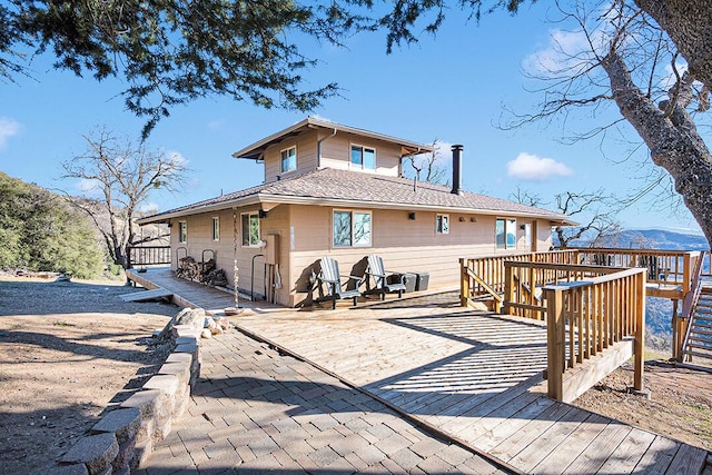 rear view of house featuring a deck with mountain view