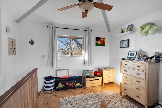 interior space featuring ceiling fan, light hardwood / wood-style flooring, and vaulted ceiling with beams