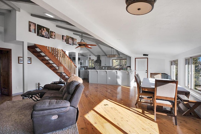 living room with lofted ceiling with beams, a healthy amount of sunlight, ceiling fan, and light hardwood / wood-style flooring