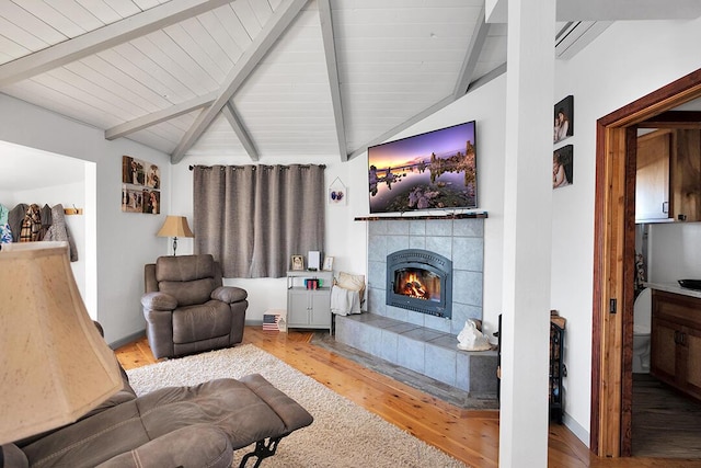 living room with hardwood / wood-style floors, a fireplace, and vaulted ceiling with beams