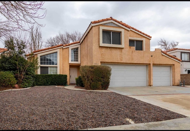 view of front facade featuring a tile roof, an attached garage, driveway, and stucco siding