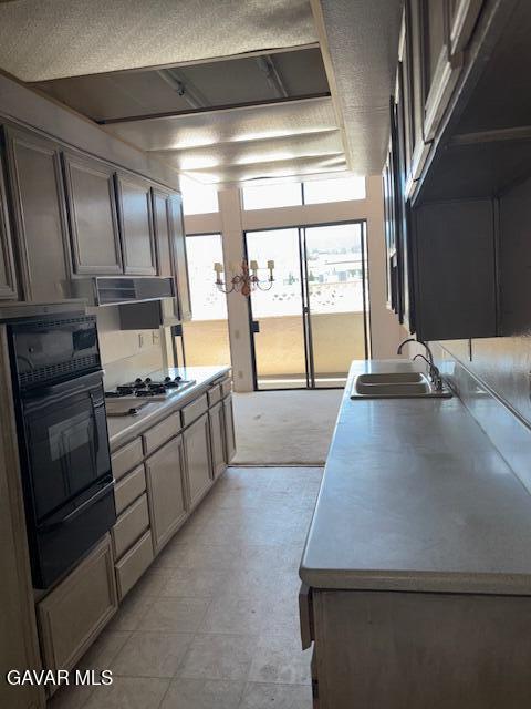 5310 Zelzah Ave Unit 305, Encino, CA 91316 - kitchen featuring a warming drawer, gas stovetop, black oven, light countertops, and range hood