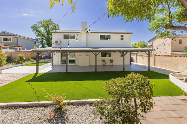 back of house with a lawn