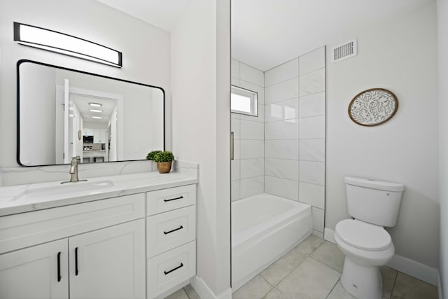 full bathroom featuring tiled shower / bath, tile patterned flooring, vanity, and toilet