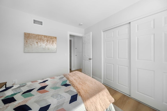 bedroom with wood-type flooring and a closet