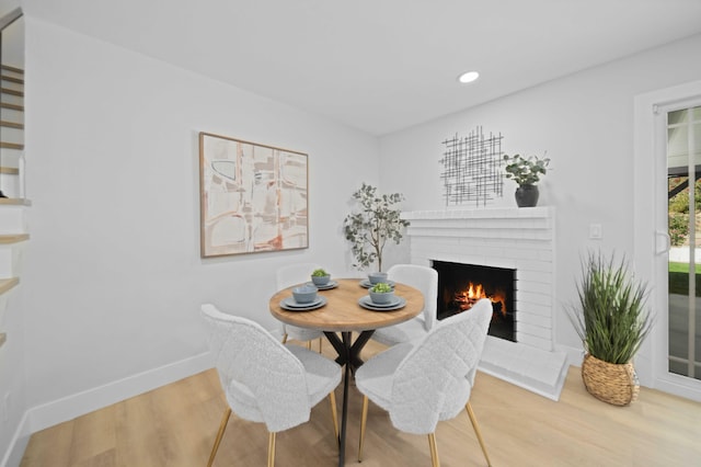 dining space with a fireplace and hardwood / wood-style floors