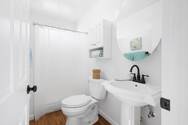 bathroom featuring wood finished floors, toilet, baseboards, and a shower with shower curtain