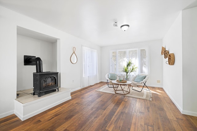 dining area with a wood stove, hardwood / wood-style floors, and baseboards