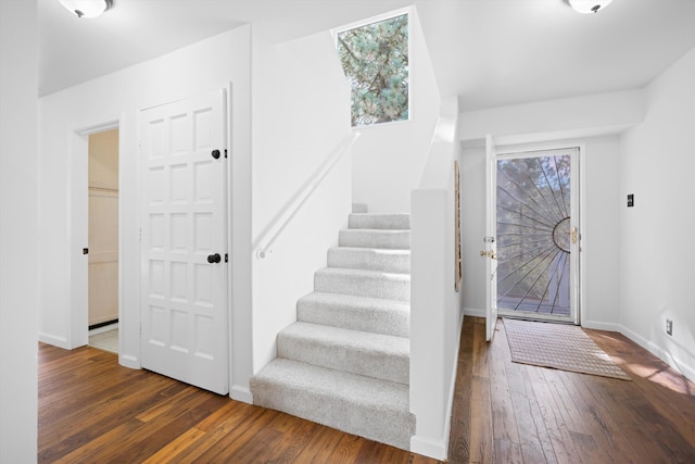 entrance foyer with stairs, wood-type flooring, baseboards, and healthy amount of natural light