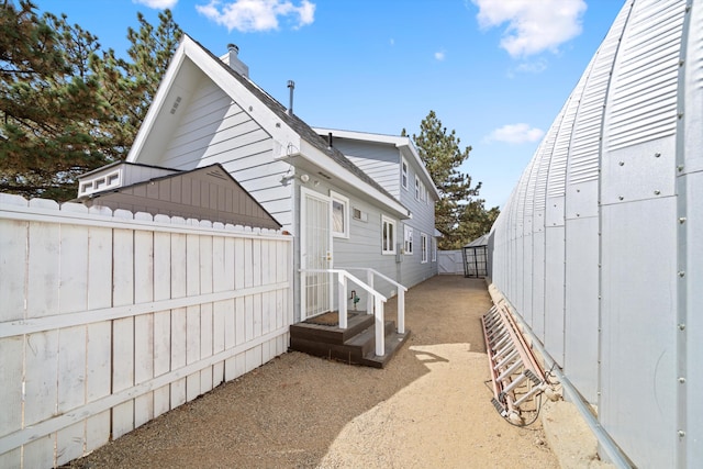 view of side of property featuring fence and a chimney