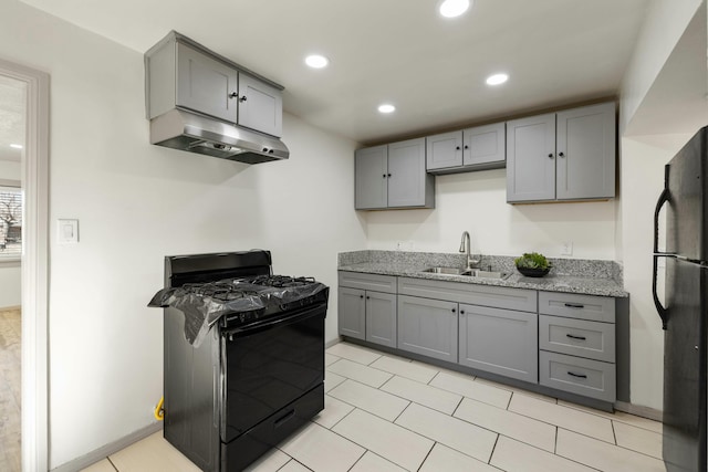 kitchen featuring under cabinet range hood, gray cabinets, black appliances, and a sink