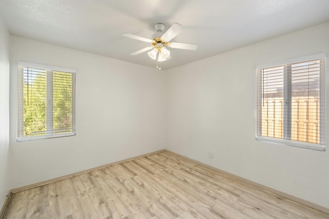 spare room featuring light wood finished floors and a ceiling fan