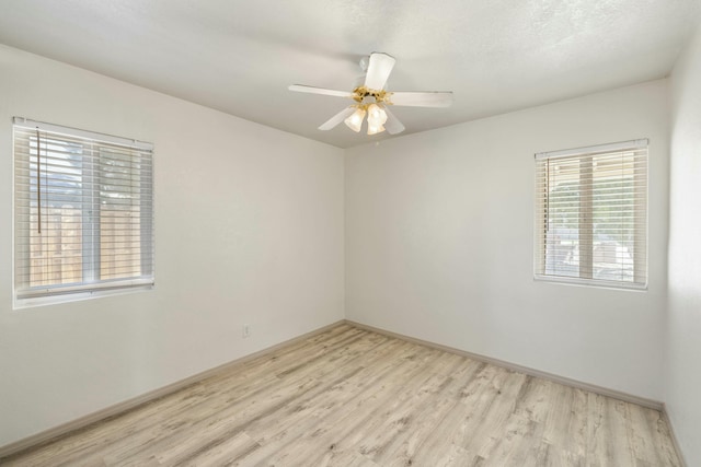 unfurnished room with a textured ceiling, light wood-style floors, and a ceiling fan