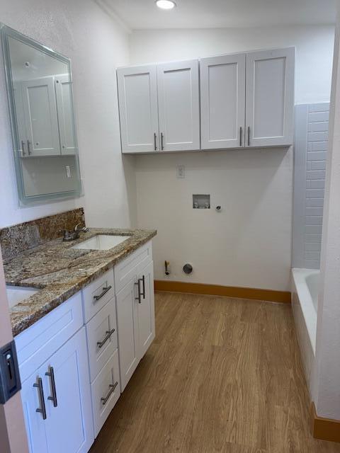 43427 Fairglen Rd, Lancaster, CA 93535 - laundry area featuring hookup for a washing machine, wood finished floors, cabinet space, hookup for a gas dryer, and baseboards