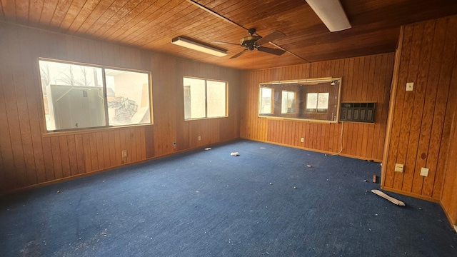 unfurnished room featuring carpet flooring, wood ceiling, and wooden walls