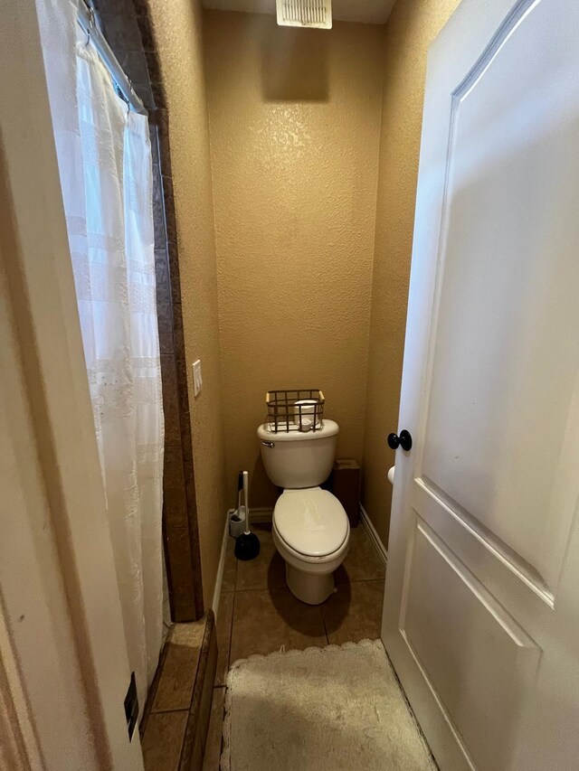 bathroom with tile patterned flooring and toilet