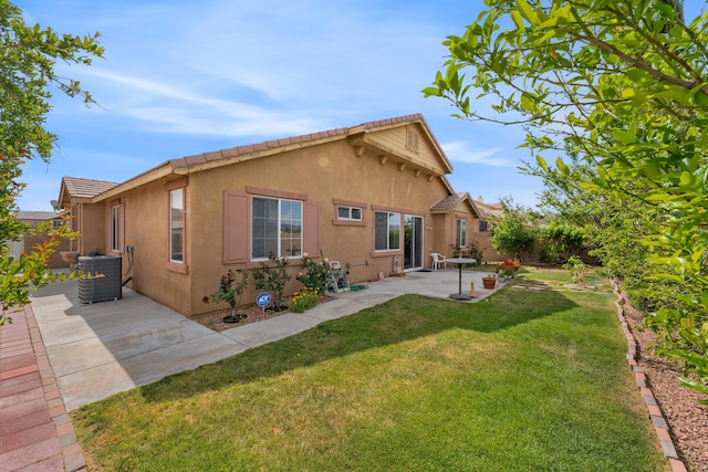 back of property featuring a yard, stucco siding, cooling unit, and a patio area