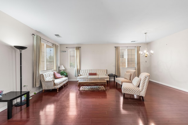 living room featuring baseboards, a notable chandelier, dark wood-style floors, and visible vents