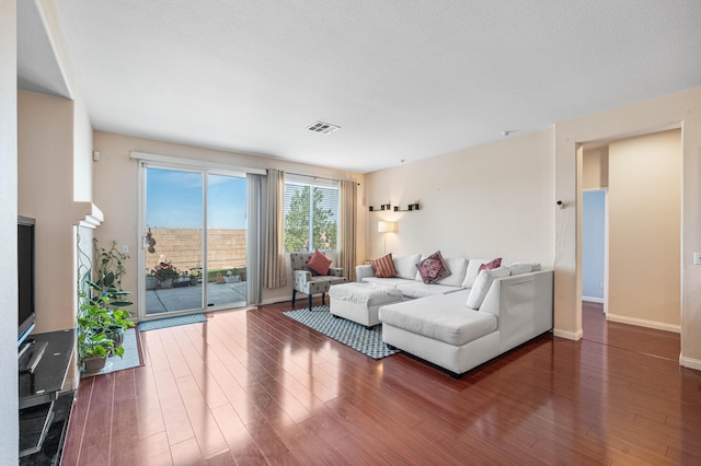 living area with baseboards, wood finished floors, and visible vents