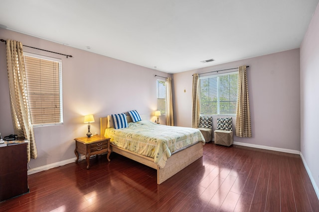bedroom featuring baseboards, wood finished floors, and visible vents