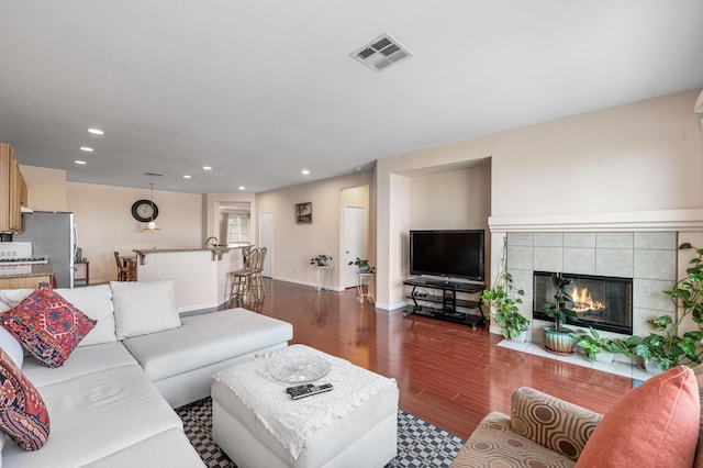 living area with visible vents, a fireplace, baseboards, dark wood-style floors, and recessed lighting