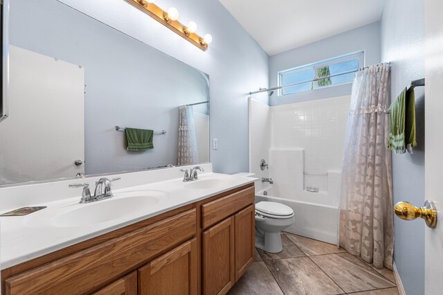 bathroom featuring double vanity, a sink, shower / bath combination with curtain, and toilet