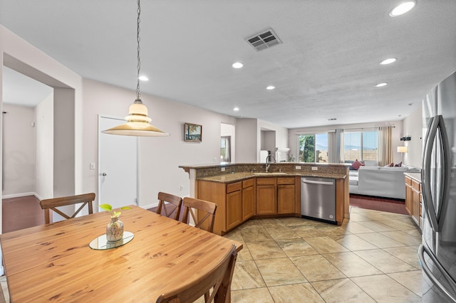 kitchen with recessed lighting, a sink, appliances with stainless steel finishes, and brown cabinets