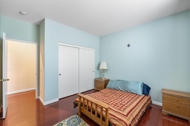 bedroom featuring baseboards, a closet, and wood finished floors