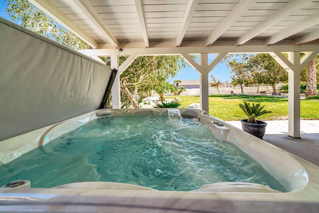 view of swimming pool featuring a hot tub and a lawn