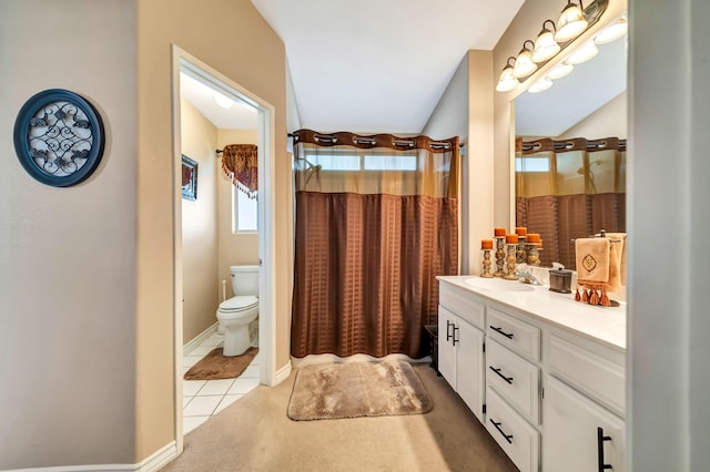 bathroom featuring tile patterned flooring, vanity, toilet, and walk in shower