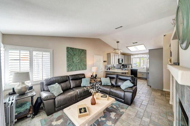 living room with lofted ceiling and a fireplace