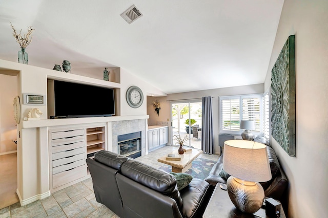 living room with lofted ceiling and a tile fireplace