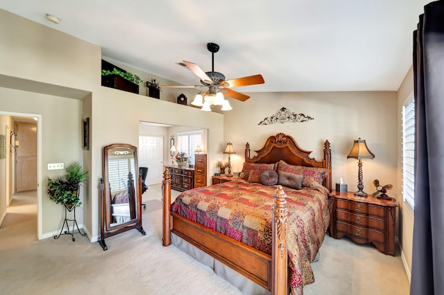 bedroom featuring ceiling fan, vaulted ceiling, light carpet, and multiple windows