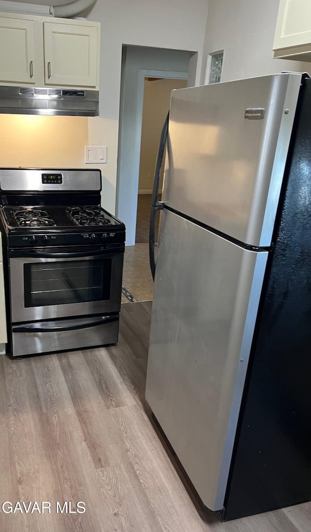 3358 Martin Ave, Mojave, CA 93501 - kitchen featuring stainless steel appliances, under cabinet range hood, white cabinetry, and light wood finished floors