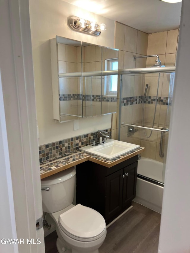 3358 Martin Ave, Mojave, CA 93501 - full bathroom featuring vanity, combined bath / shower with glass door, wood finished floors, and backsplash