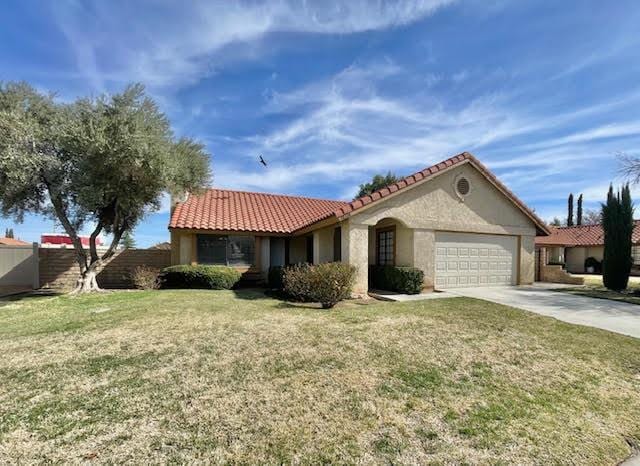 view of front of property with driveway, stucco siding, a garage, and a front yard