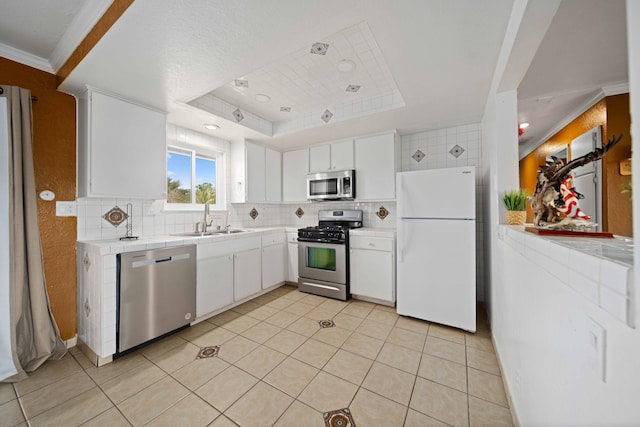 40103 E 169th St, Palmdale, CA 93591 - kitchen with appliances with stainless steel finishes, a sink, tile countertops, backsplash, and crown molding