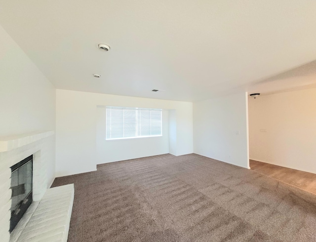 unfurnished living room with carpet floors and a brick fireplace