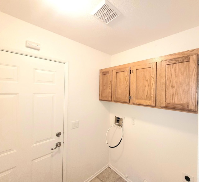 washroom with tile patterned floors, hookup for a washing machine, and cabinets