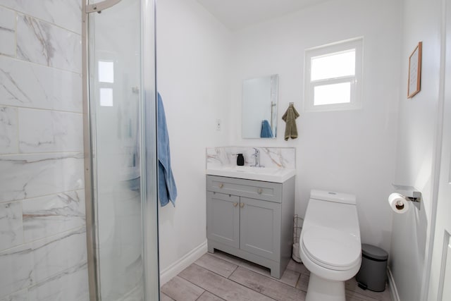 45522 Andale Ave, Lancaster, CA 93535 - full bathroom featuring toilet, vanity, a marble finish shower, baseboards, and wood finish floors