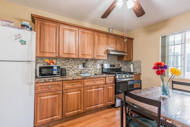 22437 Haynes St, West Hills, CA 91307 - kitchen with brown cabinetry, stainless steel appliances, a sink, and under cabinet range hood