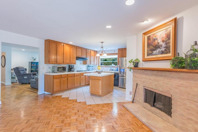 22437 Haynes St, West Hills, CA 91307 - kitchen with stainless steel appliances, under cabinet range hood, backsplash, light countertops, and a center island