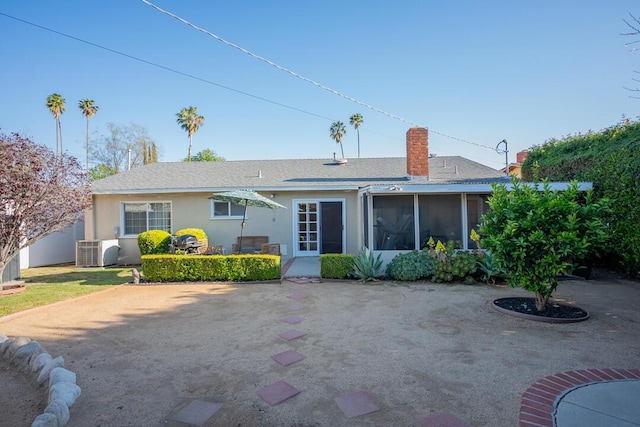 22437 Haynes St, West Hills, CA 91307 - rear view of house with a patio, a sunroom, stucco siding, a chimney, and central air condition unit