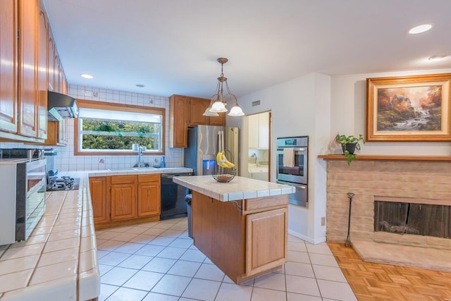22437 Haynes St, West Hills, CA 91307 - kitchen featuring exhaust hood, a warming drawer, a kitchen island, tile counters, and stainless steel appliances